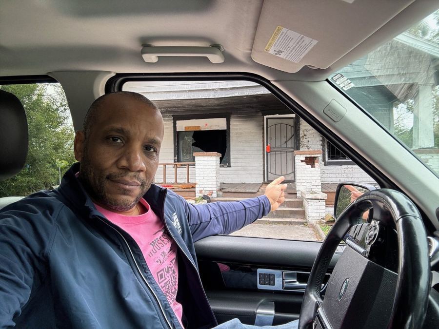 Chris pointing at a fire damaged house